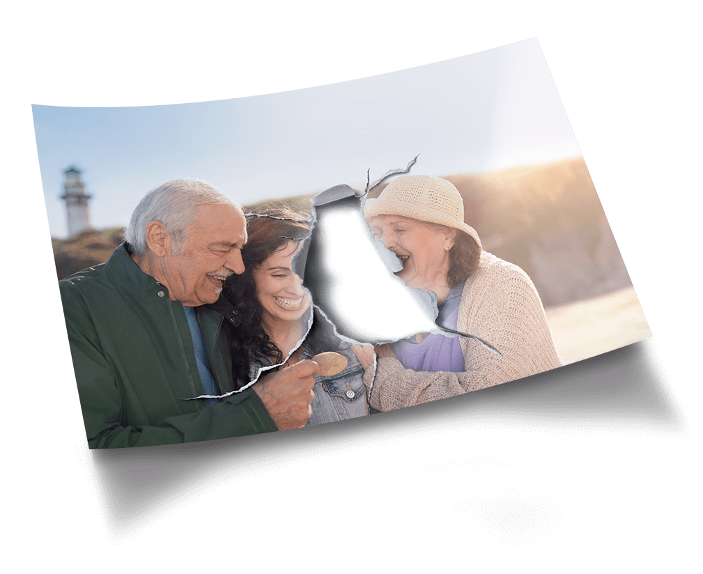 Picture of a smiling family on a beach with a piece at the center of the photo torn open